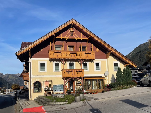 Traditionelles Gebäude in Maurach, das die Praxis von Dr. Martina Rinner beherbergt, mit dekorativen Holzdetails und einladender Fassade, eingebettet in eine malerische Berglandschaft.