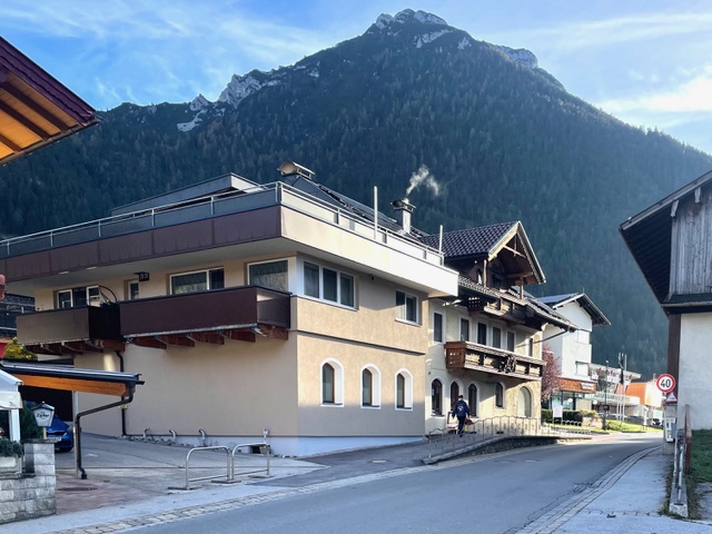 Gebäude in Maurach in der Nähe der Praxis von Dr. Martina Rinner, umgeben von alpiner Landschaft und vor der Kulisse eines bewaldeten Berges, das den ruhigen und naturnahen Standort der Praxis hervorhebt.